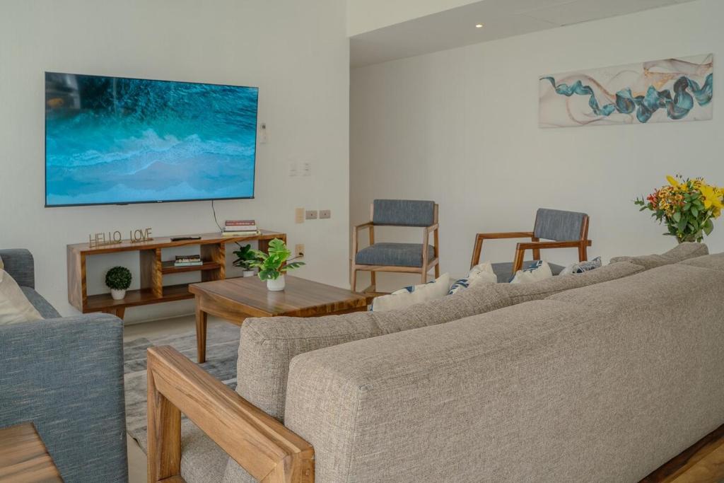 a living room with couches and a flat screen tv at Nitta 301 Escápate a Nuevo Vallarta in Nuevo Nayarit
