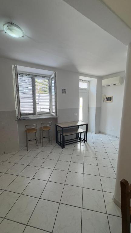 an empty room with a table and chairs in it at case vacanza hoya in Lacco Ameno