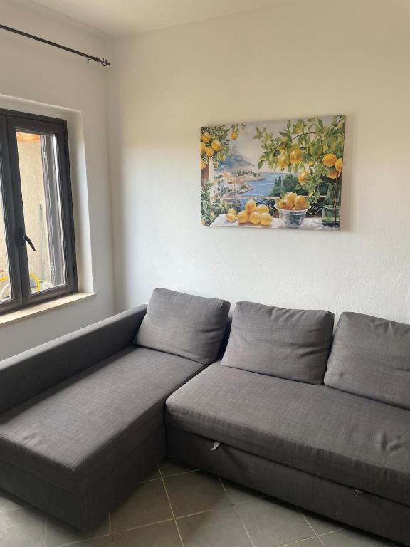 a couch in a living room with a painting on the wall at Villa del Limone in Sellia Marina
