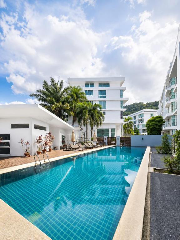 a swimming pool in front of a building at Dee Residence Phuket in Patong Beach