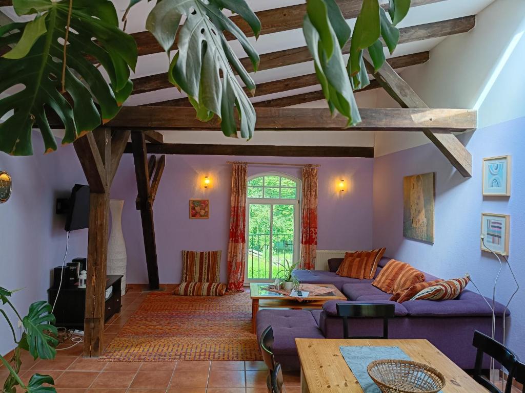 a living room with a blue couch and a table at Ferien am Schloss - Wohnung 5 "der Hahn", Ferienwohnung am Badesee in Behren-Lübchin