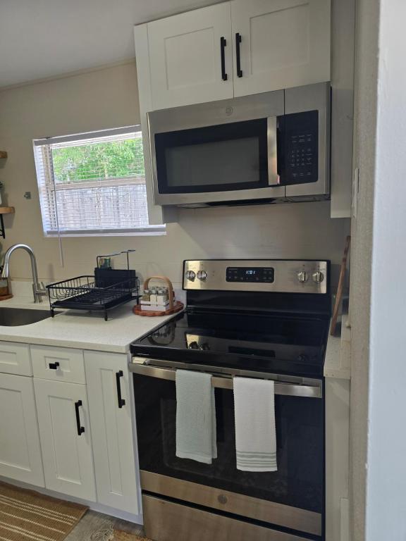 a kitchen with a stove and a microwave at Welcome to this romantic getaway in Sarasota