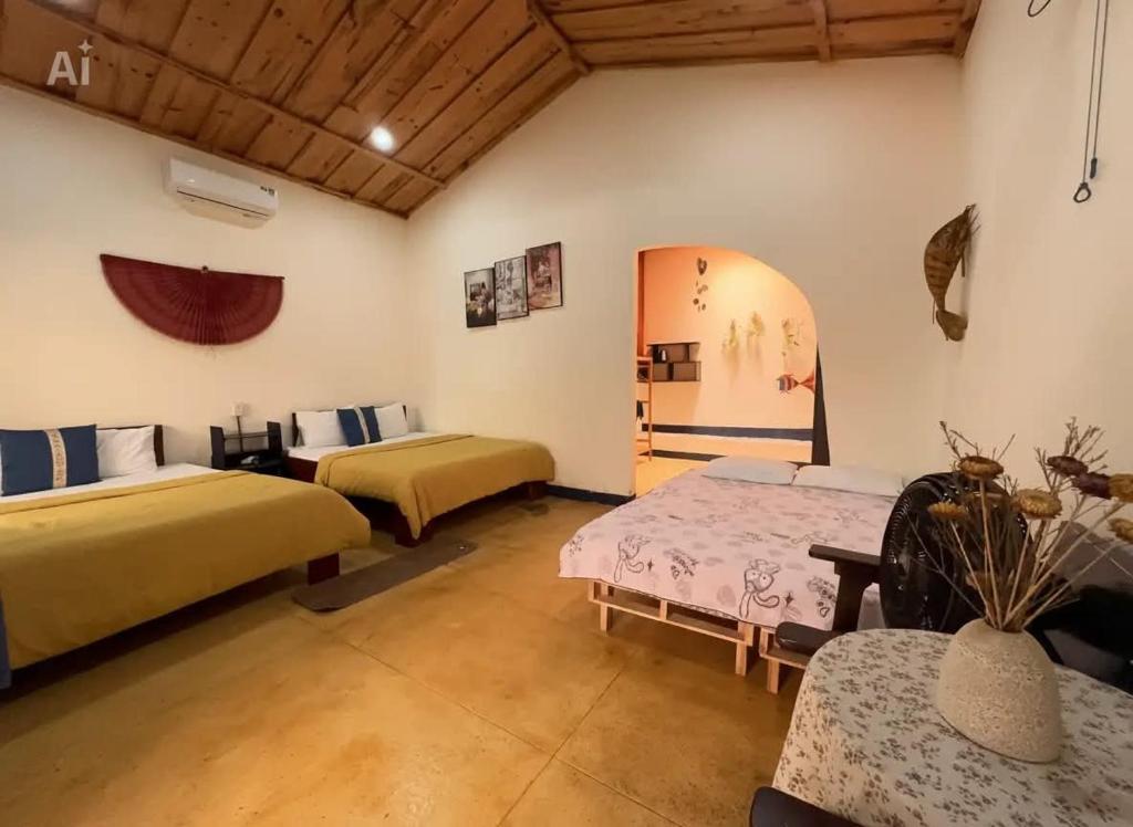 a room with two beds and two tables in it at Family Room in Tam Kỳ