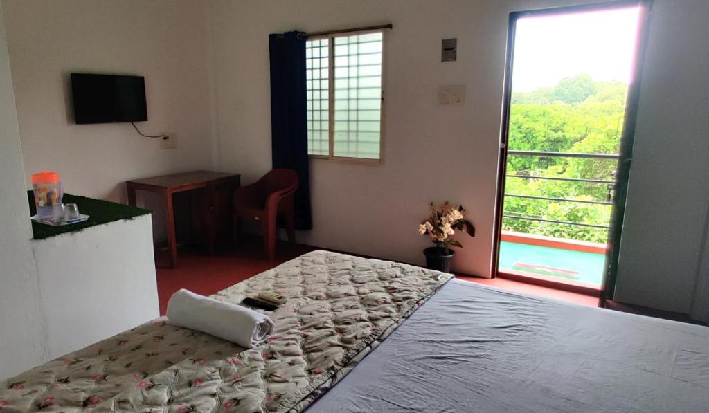 a bedroom with a large bed and a large window at Nature Nest In in Auroville