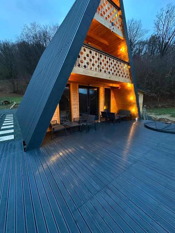 a house with a large wooden deck at Cabana La Poiata in Valea Chioarului