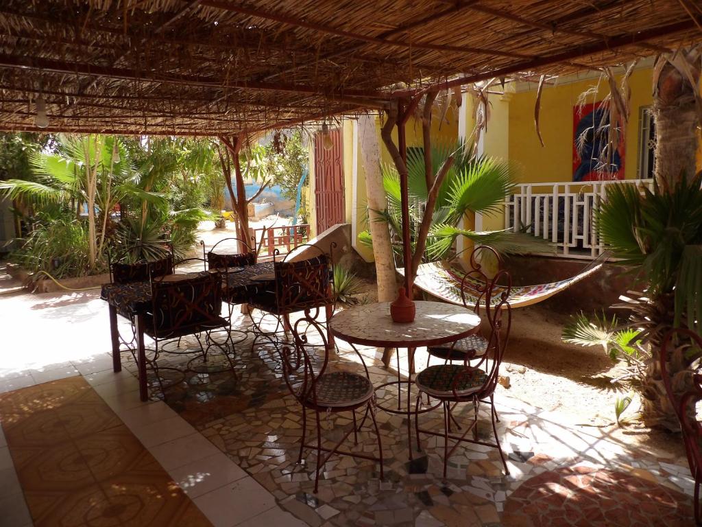 an outdoor patio with tables and chairs and a porch at Auberge Triskell in Nouakchott