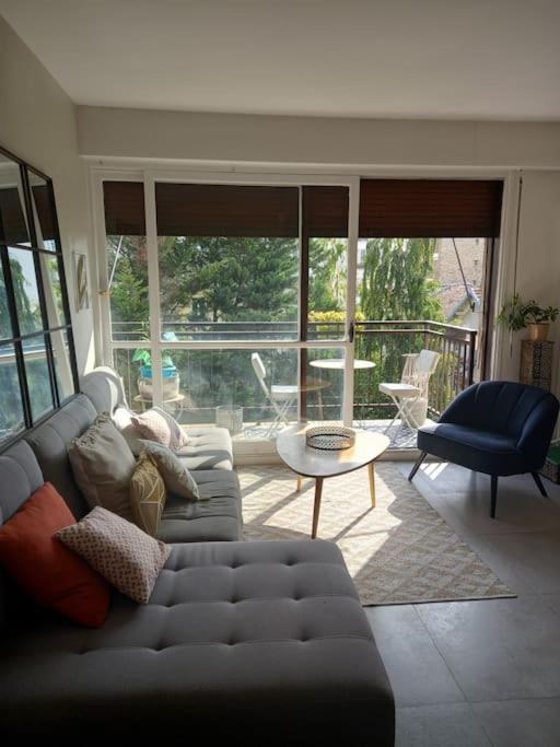 a living room with a couch and a table at Appartement,clair au calme avec balcon in Fontenay-sous-Bois