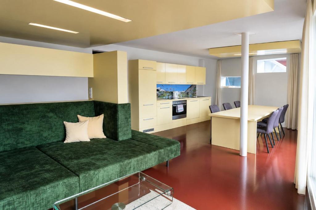 a living room with a green couch and a table at Sun Matrei Apartments in Matrei in Osttirol