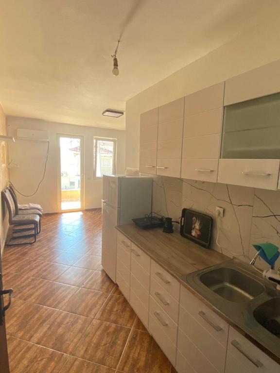 a kitchen with white cabinets and a sink at Apartmani Adelisa in Šušanj
