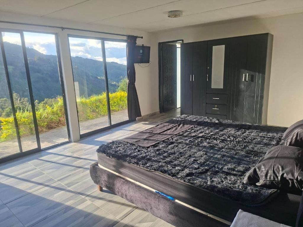 a bedroom with a bed with a view of the mountains at Alojamiento Campestre Barachel in Pamplona