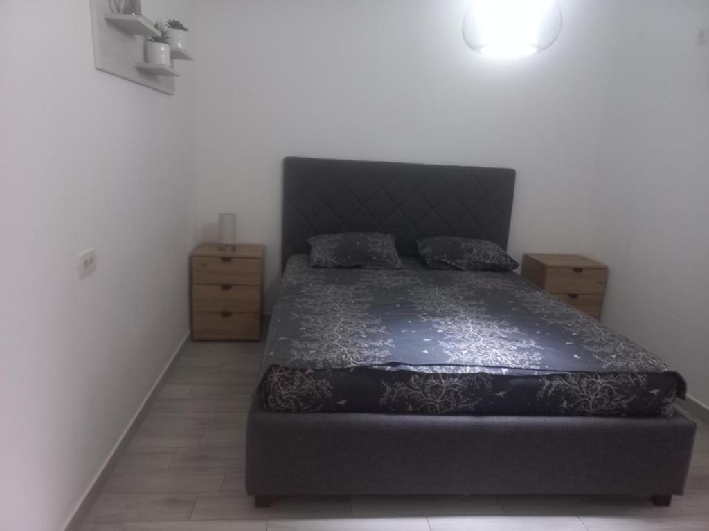 a bedroom with a bed with a black comforter at Asijaapartmani in Bar