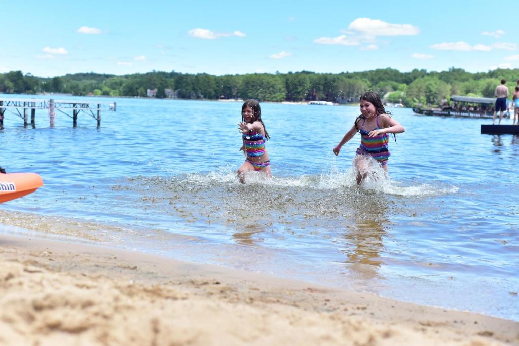 two girls playing in the water at the beach at Delton Oaks Resort Motel in Wisconsin Dells
