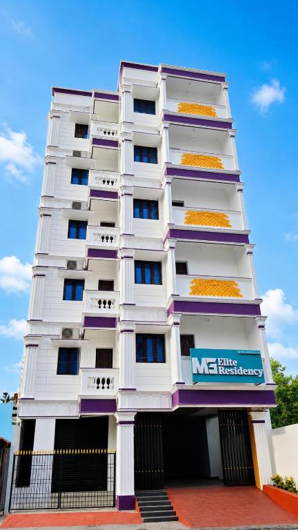 a white building with a nes hotel sign on it at MG Elite Residency in Pondicherry