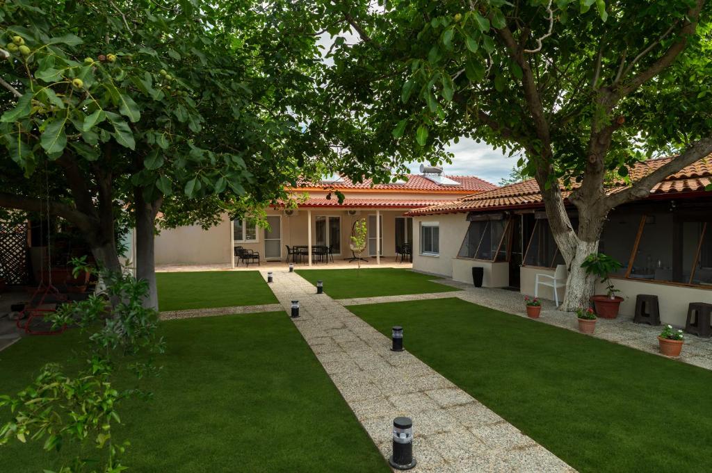 a courtyard of a house with green grass and trees at Annasa Suites 1 in Mángana