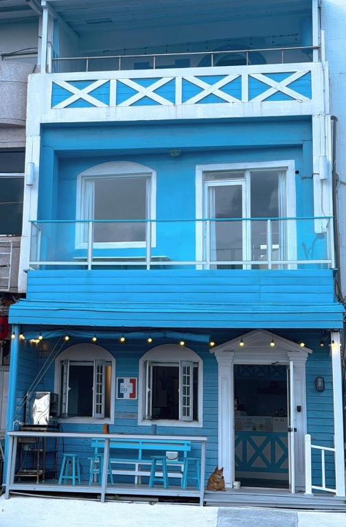 a blue building with a porch and a balcony at 燈塔情人歐風海景民宿 in Eluan