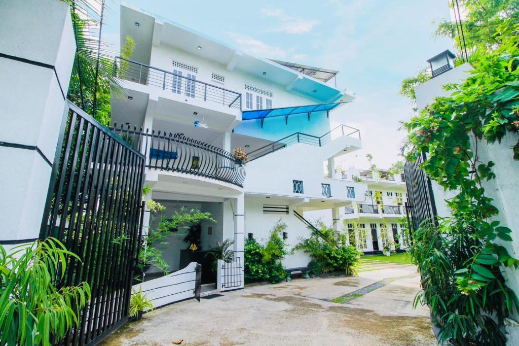 a white apartment building with a black fence at Lodge 52 Negombo in Negombo