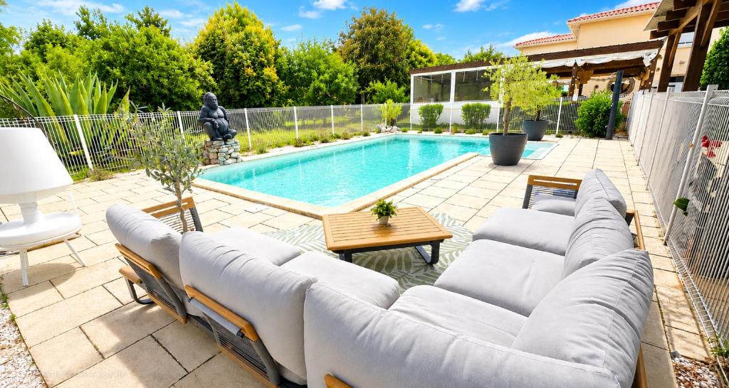 a patio with a couch and a swimming pool at Petite maisonnette avec accés piscine in Montauban