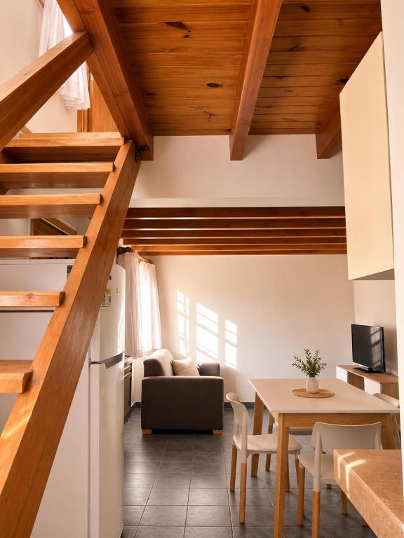 a kitchen and living room with a table and a refrigerator at Destino Patagonia in Esquel