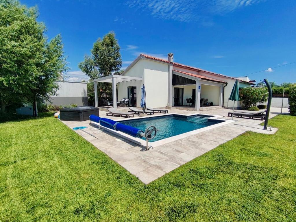 a swimming pool in a yard next to a house at Villa Alba in Vodnjan