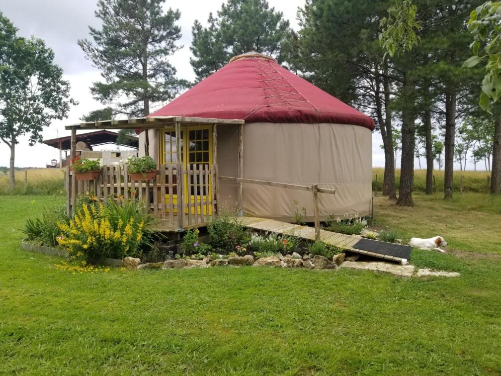 a yurt with a red roof in a field at séjourner en yourte in Gans