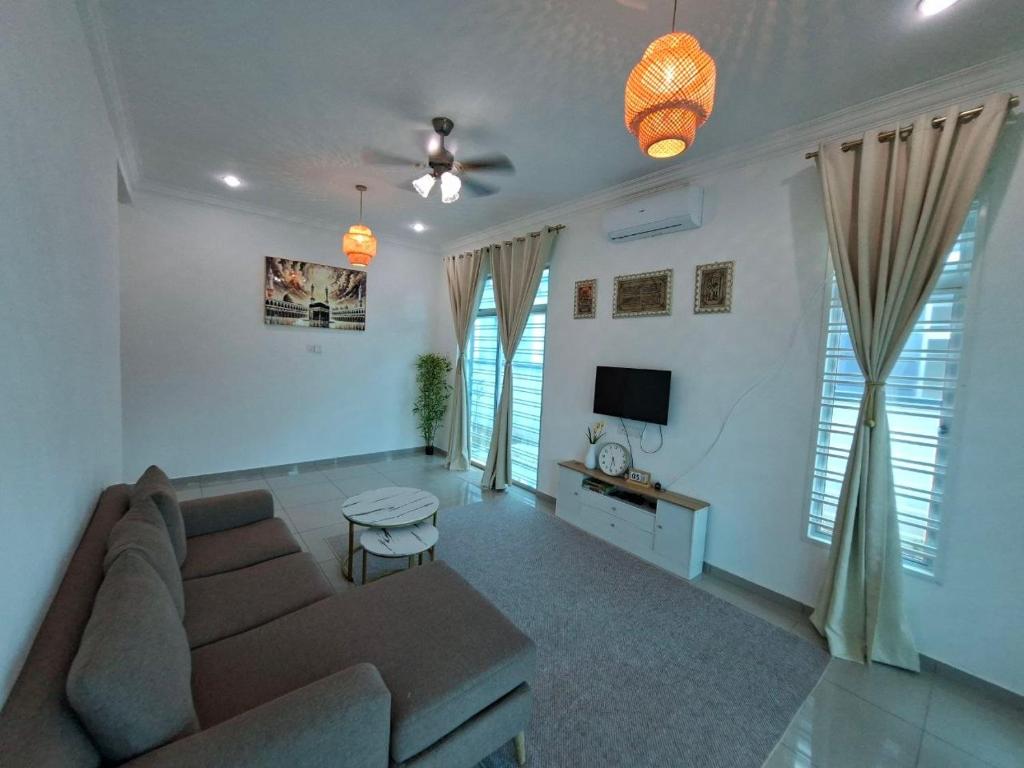 a living room with a couch and a tv at D'Biru Homestay Segamat in Segamat