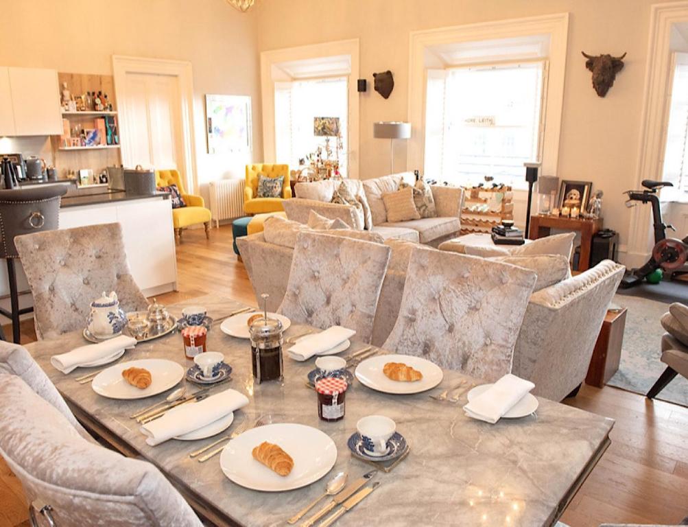 a living room with a table with plates of food on it at Bernard Street Edinburgh Apartment in Edinburgh