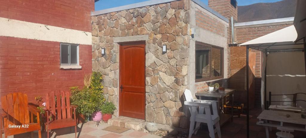 a brick building with a red door and a patio at Alojamiento Rural Polita, Agroturismo y Patrimonial in Petorca