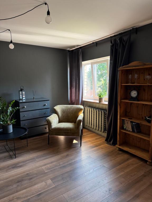 a living room with a chair and a window at OMAa in Kuldīga