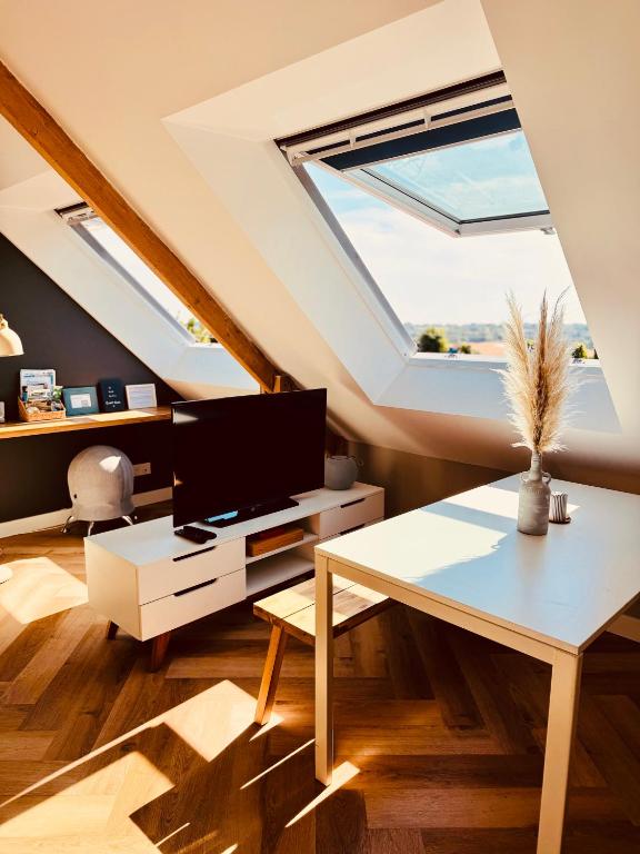 a living room with a large window and a table at Au petit Cachou in Port-Bail-sur-Mer