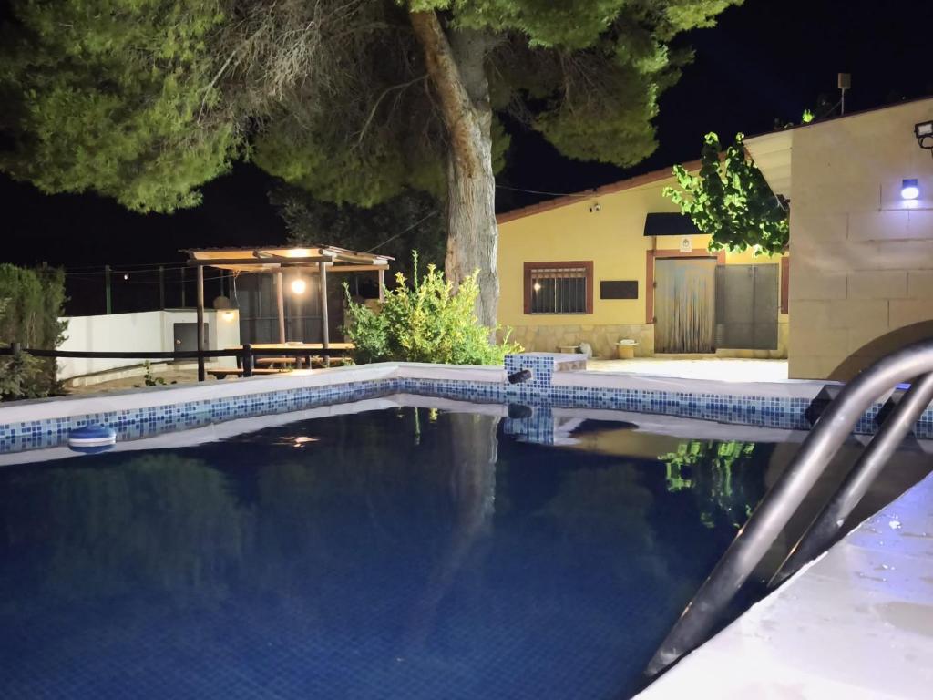 a swimming pool in front of a house at night at Casa Rural Prado Alto,Foz Calanda in Foz-Calanda