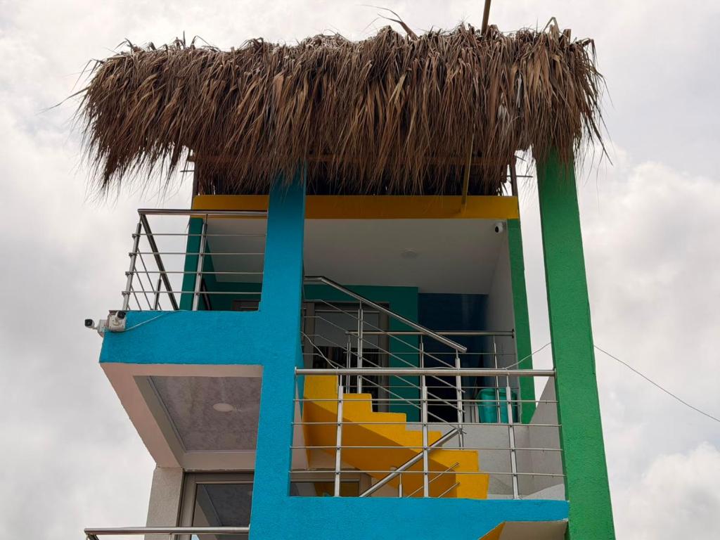 a building with a straw roof on top of it at El Gran Jeronimo Hostal Rincon del Mar in Rincón