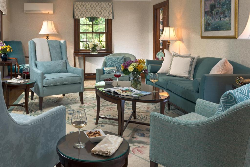 a living room with blue couches and chairs at Old Harbor Inn in Chatham