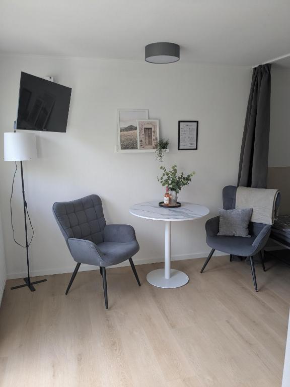 a living room with a table and two chairs and a tv at Ferienwohnung in Ranzig - klein aber fein in Tauche
