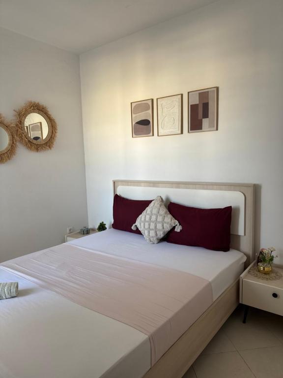 a bedroom with a large white bed with red pillows at Fès comfort stay in Fez