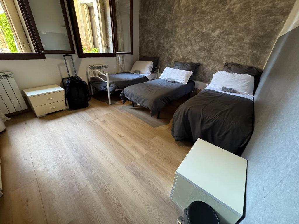 a small room with two beds and a table at venice private rooms in Venice