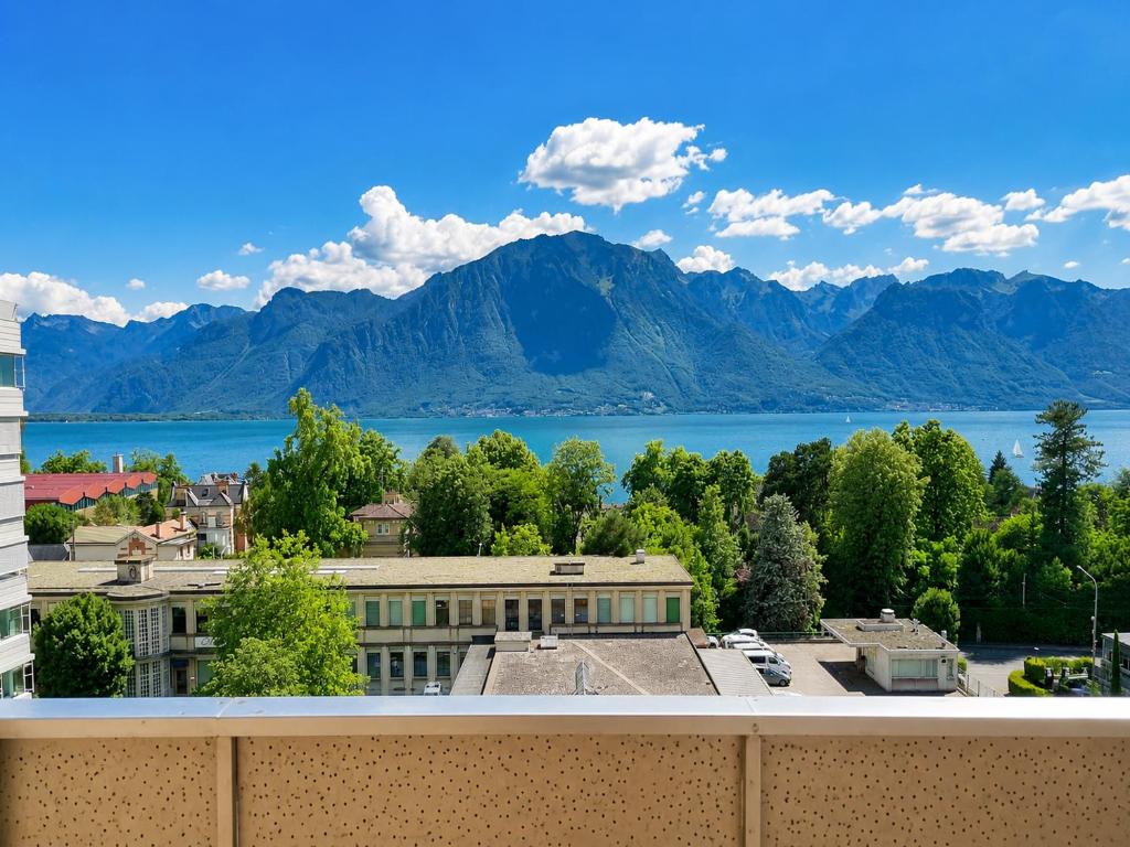 a view of the lake and mountains from a building at Bright Lake-View Apartment in Montreux