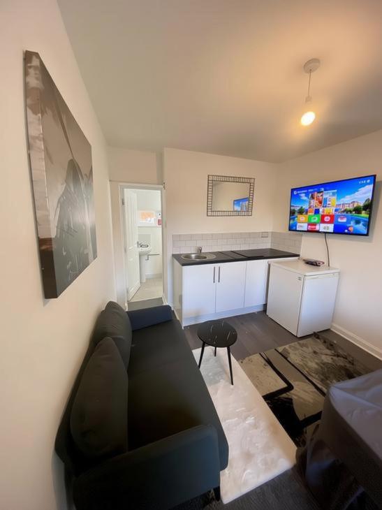 a living room with a couch and a kitchen at Coventry Escape in Longford