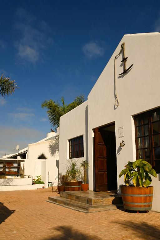 a white building with a door and some plants at Skilpadvlei Cottage and Studio's in Velddrif