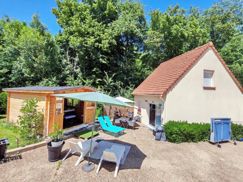 a cottage with a table and chairs and an umbrella at Celies Country Cottage in Blaru