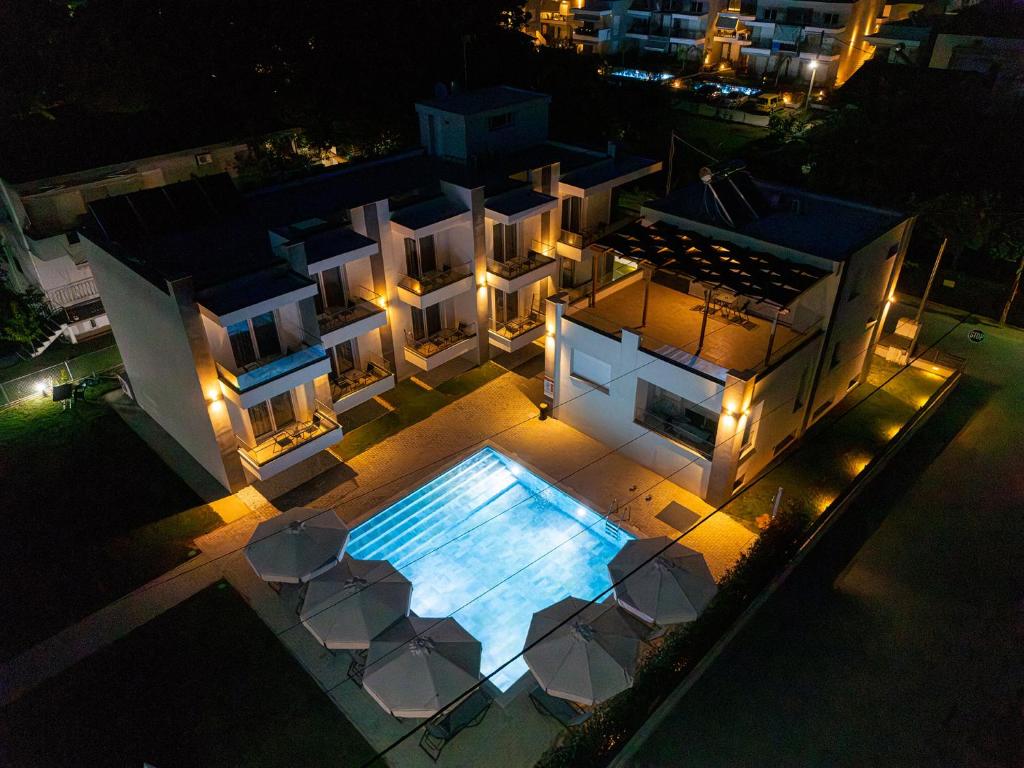 an aerial view of a house with a swimming pool at night at Porto Dionysos in Ofrínion