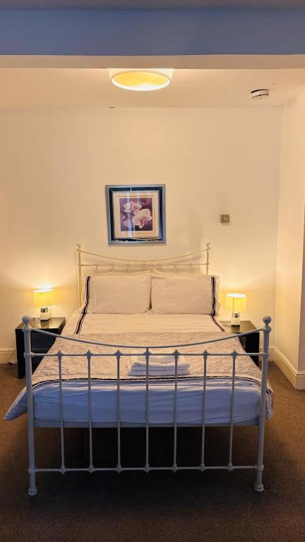 a bed in a room with two tables and two lamps at Private Ensuite Room with Bay Window, Free Parking and Fast WiFi in Sheffield