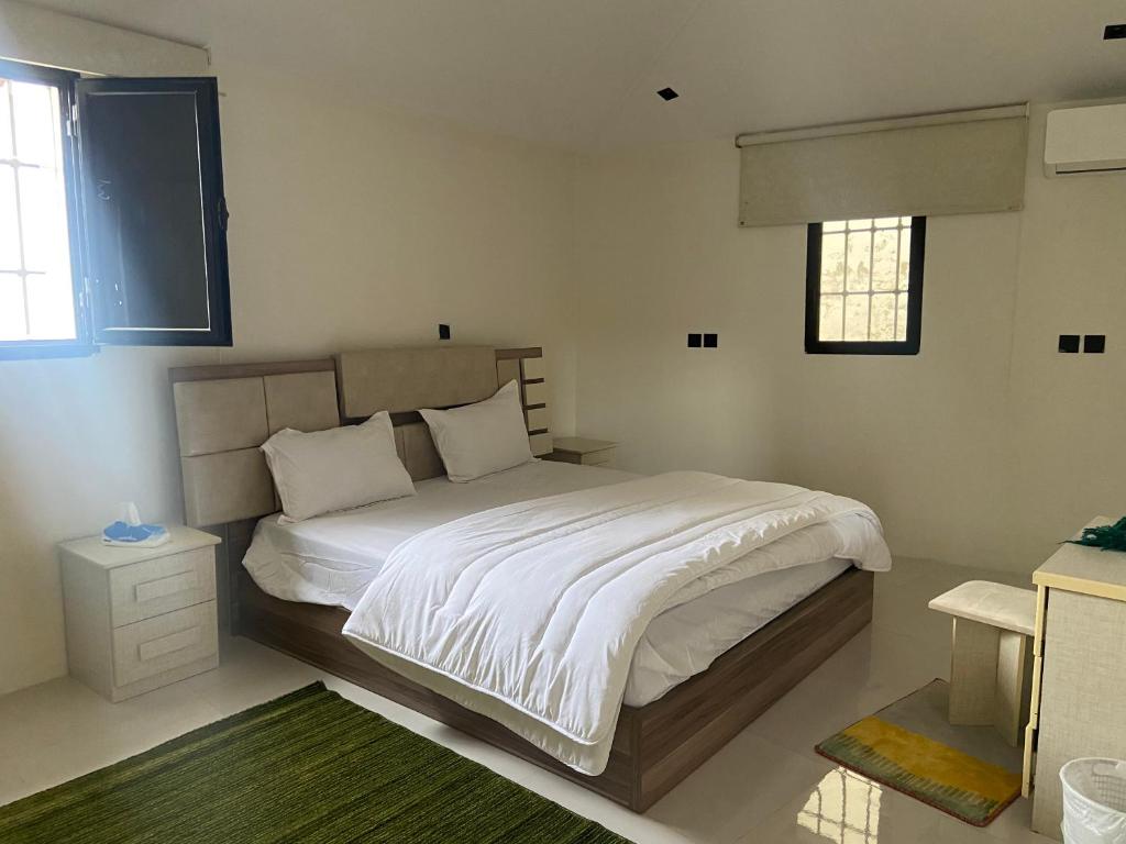 a bedroom with a large bed with white sheets at شاليه الكوثر in Al Baha