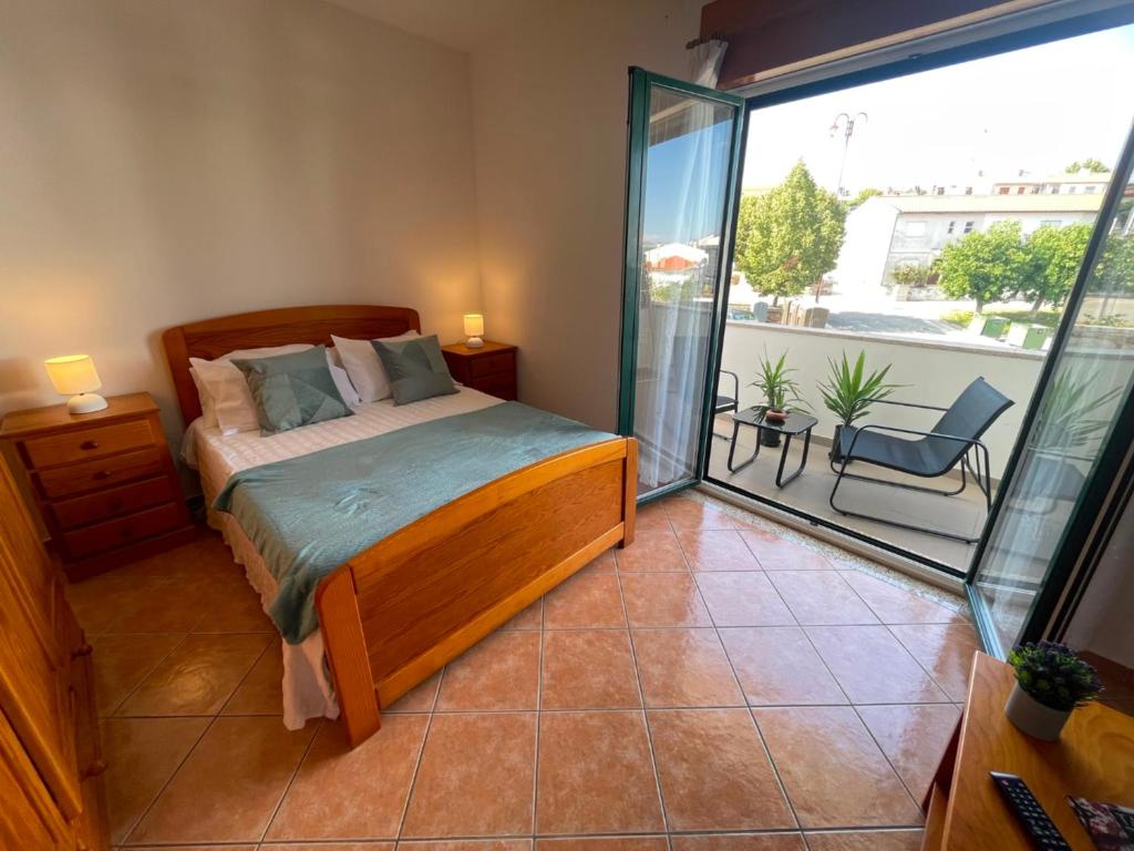 a bedroom with a bed and a balcony at Apartamento Airoso em Miranda in Miranda do Douro