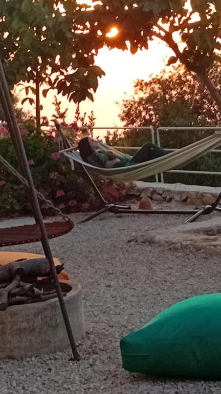 a person sleeping in a hammock in a park at Fannoun Getaway Lodge by Hansa in Ḩayy al Qal‘ah