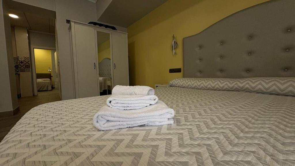 a bedroom with a bed with towels on it at Alojamientos Templete in Caravaca de la Cruz