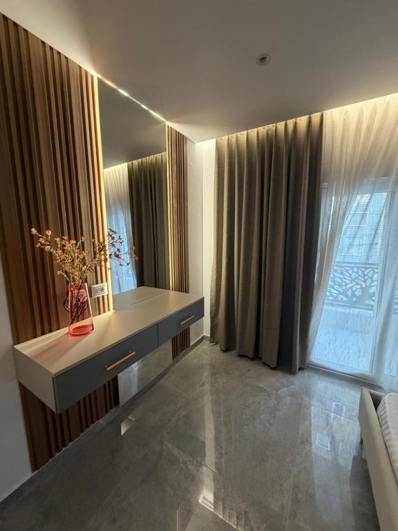 a living room with a desk and a window at Durres Beach Rooms in Durrës