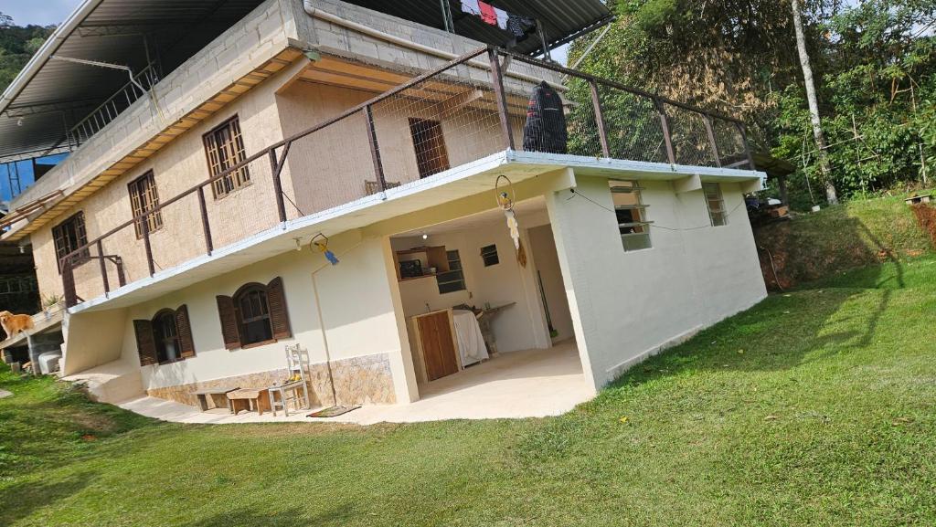 a white house with a grassy field in front of it at Recanto do majo in Petrópolis
