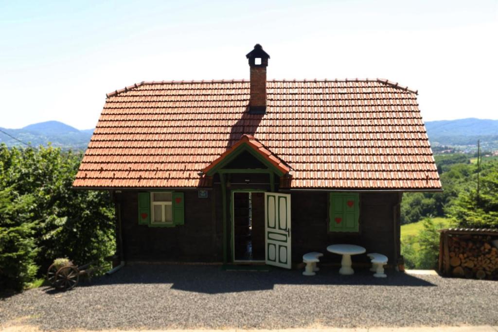 a small house with an open door and a table at Jurina Hiža in Beletinec