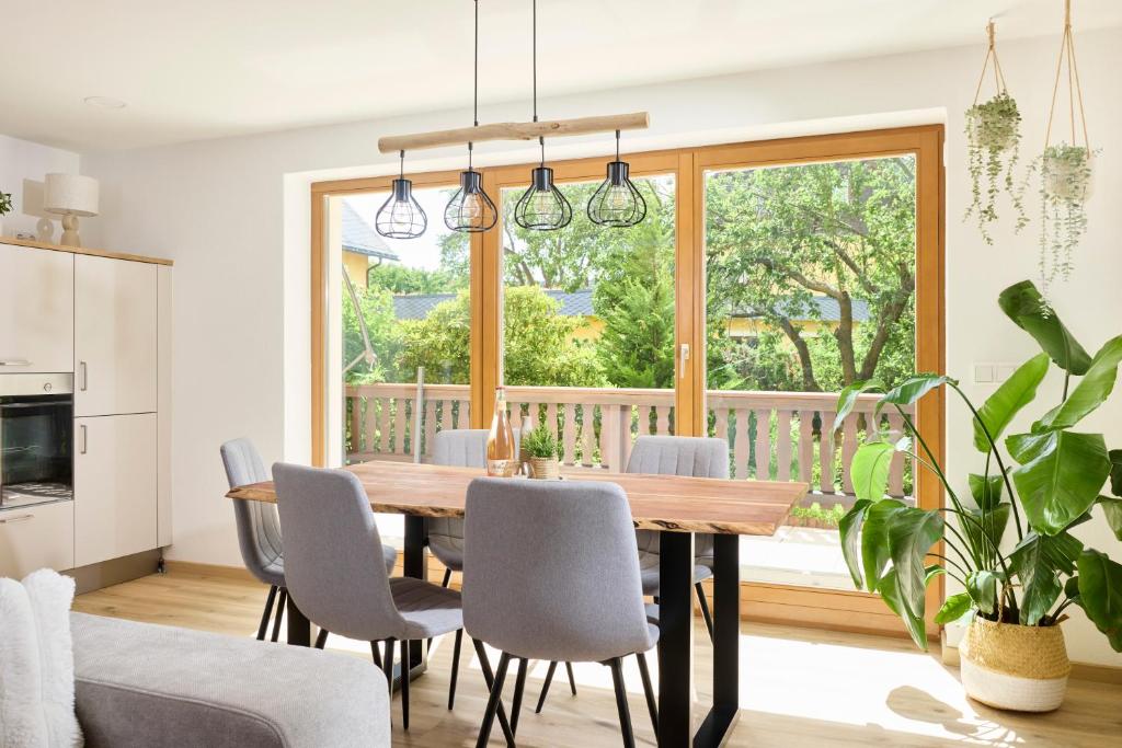 a dining room with a table and chairs and a large window at Ferienwohnung Nähe Dresden mit Pool & Spielplatz - FeWo "Waldblick" und "Gartenblick" an der Talsperre Malter in Dippoldiswalde