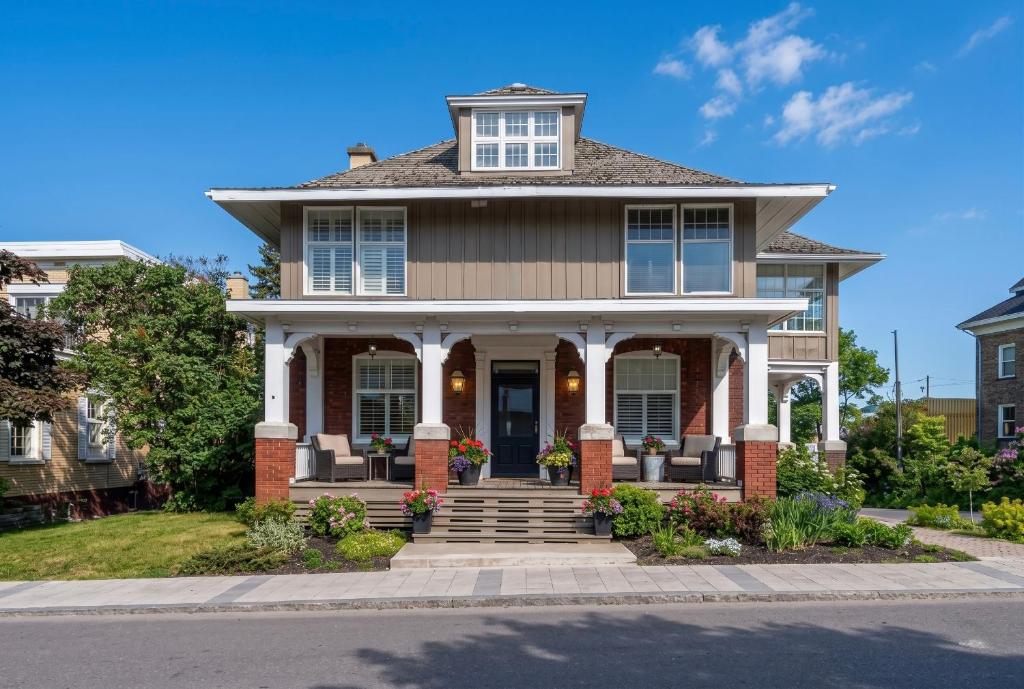 a house with a front porch with flowers at Les Suites Du Vieux-Lévis - With AC and Parking in Lévis
